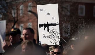 **FILE** A sign depicting an assault rifle is held up at a pro-gun rights rally against a proposal by Maryland Gov. Martin O&#39;Malley that would ban assault weapons and require residents to obtain a license before purchasing handguns at Lawyers Park in front of the Maryland State House in Annapolis on Feb. 6, 2013. (Andrew Harnik/The Washington Times)