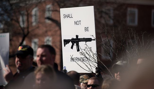 **FILE** A sign depicting an assault rifle is held up at a pro-gun rights rally against a proposal by Maryland Gov. Martin O&#x27;Malley that would ban assault weapons and require residents to obtain a license before purchasing handguns at Lawyers Park in front of the Maryland State House in Annapolis on Feb. 6, 2013. (Andrew Harnik/The Washington Times)