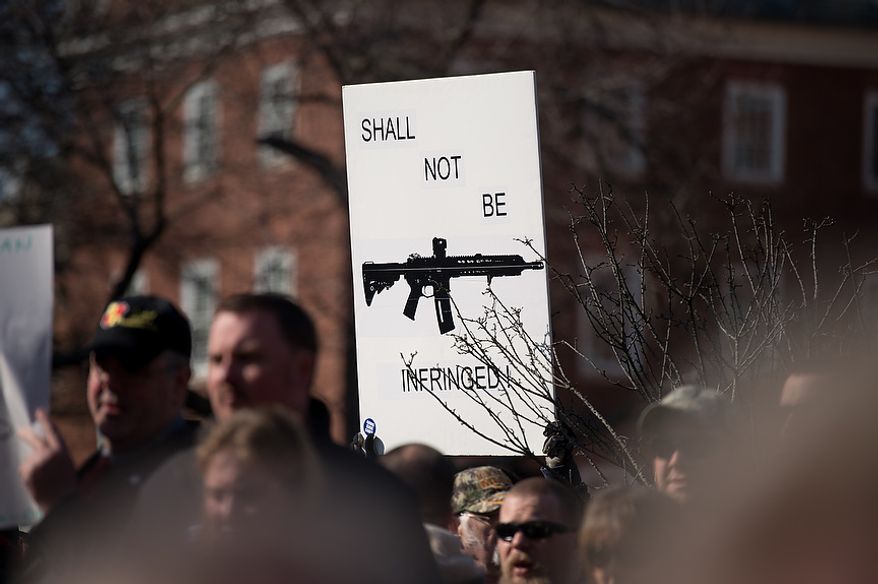 **FILE** A sign depicting an assault rifle is held up at a pro-gun rights rally against a proposal by Maryland Gov. Martin O'Malley that would ban assault weapons and require residents to obtain a license before purchasing handguns at Lawyers Park in front of the Maryland State House in Annapolis on Feb. 6, 2013. (Andrew Harnik/The Washington Times)