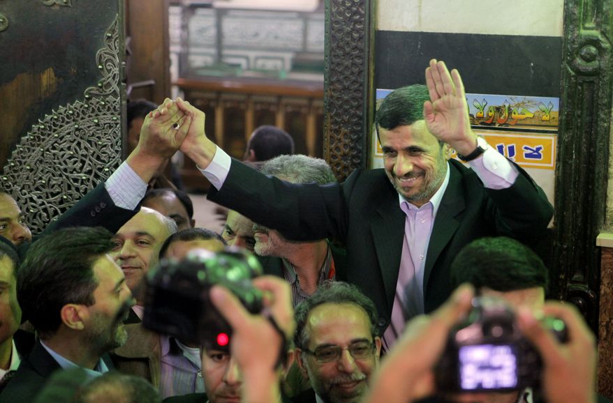 Iran's President Mahmoud Ahmadinejad, center, waves to Egyptians worshippers in front of the shrine of Imam Hussein, the grandson of Islam's Prophet Mohammad, in Cairo, Egypt, Tuesday, Feb. 5, 2013. (AP Photo/Amr Nabil)