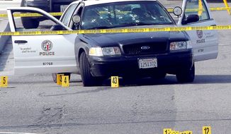 A bullet-damaged Los Angeles police vehicle with crime scene tape around it sits on a street in Corona, Calif. Christopher Jordan Dorner is being sought after three killings. (Associated Press)
