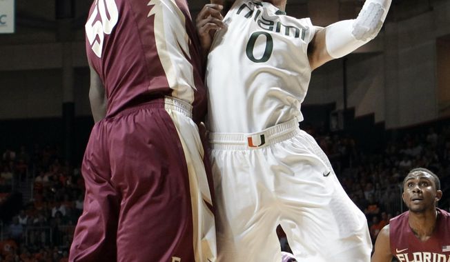 Miami&#x27;s Shane Larkin (0) prepares to shoot against Florida State&#x27;s Michael Ojo (50) during the first half of an NCAA college basketball game in Coral Gables, Fla., Sunday, Jan. 27, 2013. (AP Photo/Alan Diaz)