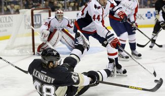 Pittsburgh Penguins&#39; Tyler Kennedy (48) controls the puck from a seated position as Washington Capitals&#39; Roman Hamrlik (44) defends in the second period of an NHL hockey game Thursday, Feb. 7, 2013, in Pittsburgh. (AP Photo/Keith Srakocic)