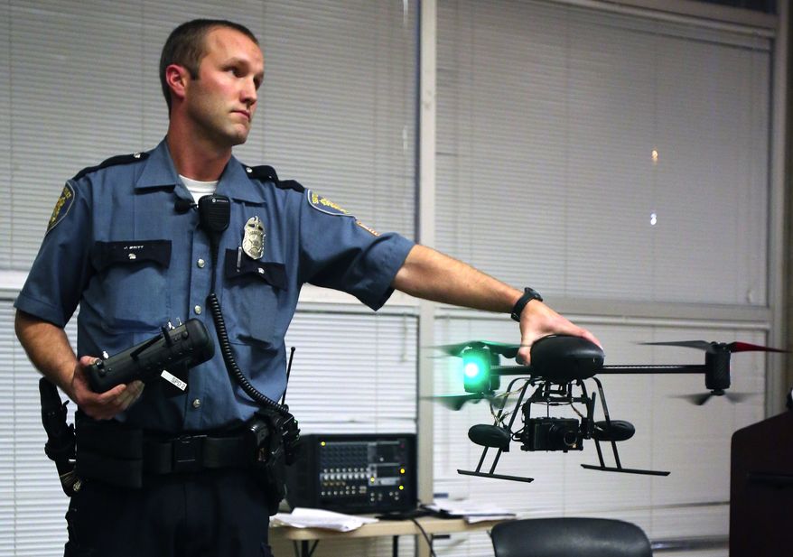 ** FILE ** Seattle police Officer Jim Britt demonstrates an unmanned aerial vehicle during an informational meeting at which the police attempted answer questions about their drone program at the Garfield Community Center in Seattle on Thursday, Oct. 25, 2012. The mayor of Seattle ended the police department's drone program in February after residents protested. (AP Photo/The Seattle Times, Colin Diltz)