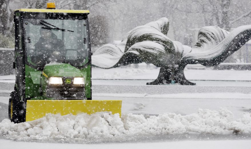 Kevin Quick plows a slushy mix in front of an M&T Bank branch in Buffalo, N.Y., during a winter storm on Feb. 8, 2013. (Associated Press)