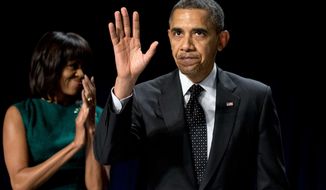 First lady Michelle Obama applauds as President Obama waves after speaking at the National Prayer Breakfast in Washington on Feb. 7, 2013. (Associated Press)