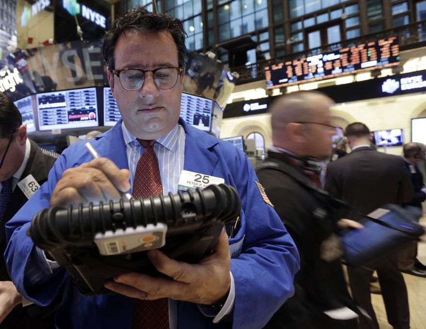 Trader Peter Costa (left) works on the floor of the New York Stock Exchange on Feb. 8, 2013. (Associated Press)