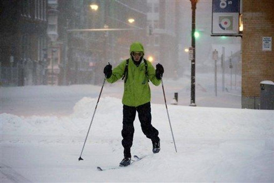 A pedestrian uses skis to travel through the deserted snow-covered streets of Boston early Saturday, Feb. 9, 2013. (Associated Press)