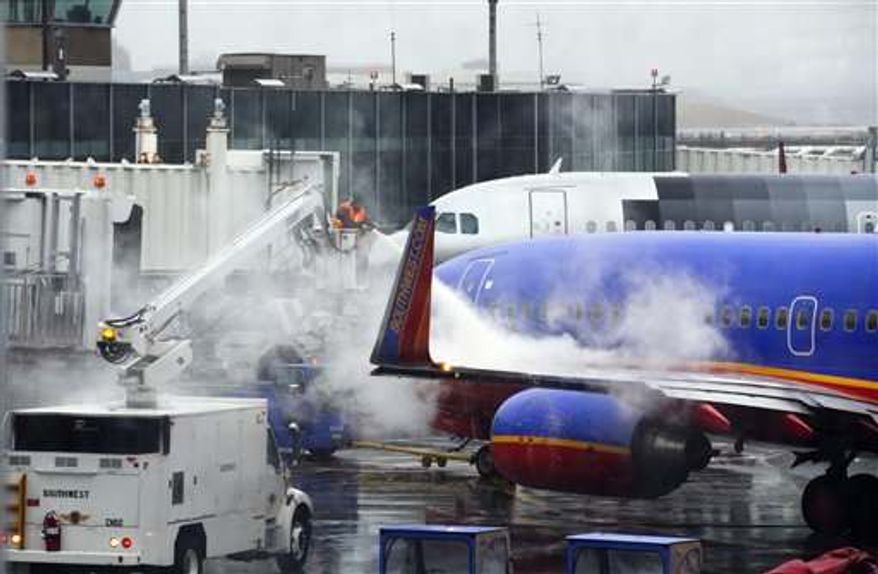 Grounds crews prepare a plane for flight at LaGuardia Airport Friday, Feb. 8, 2013, in New York. Most airlines were giving up on flying in and out of New York, Boston and other airports in the American Northeast on Friday as a massive storm threatened to dump up to a meter of snow in some parts. (AP Photo/Frank Franklin II)