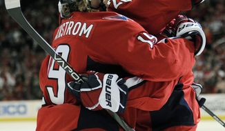 Washington Capitals defenseman John Carlson, right, celebrates a goal scored by teammate Troy Brouwer (20) and Nicklas Backstrom (19), of Sweden, during the first period of an NHL hockey game against the Florida Panthers, Saturday, Feb. 9, 2013, in Washington. (AP Photo/Nick Wass)