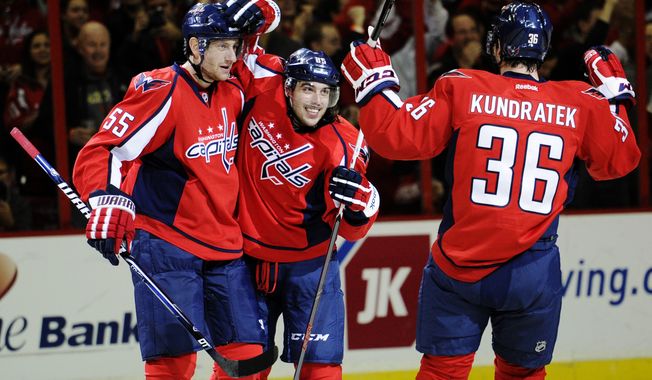 Washington Capitals center Mathieu Perreault (85) celebrates his goal with Jeff Schultz (55) and Tomas Kundratek (36), of the Czech Republic, during the third period of an NHL hockey game against the Florida Panthers, Saturday, Feb. 9, 2013, in Washington. The Capitals won 5-0. (AP Photo/Nick Wass)