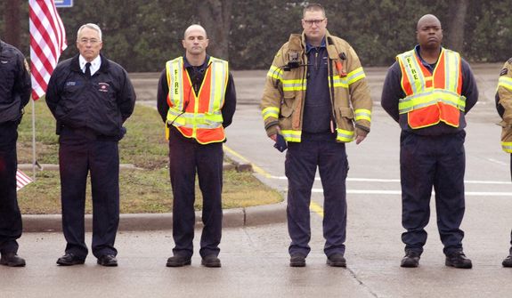 Members of Midlothian Fire Department pay their respects during a procession for Chris Kyle in Midlothian, Texas, Tuesday, Feb. 12, 2013, for the 200-mile journey to Austin, where Kyle will be buried at the Texas State Cemetery. Some 7,000 people attended a two-hour memorial service for Kyle at Cowboys Stadium in Arlington on Monday. Kyle and his friend Chad Littlefield were shot and killed Feb 2. at a North Texas gun range. (AP Photo/Star-Telegram, Max Faulkner)