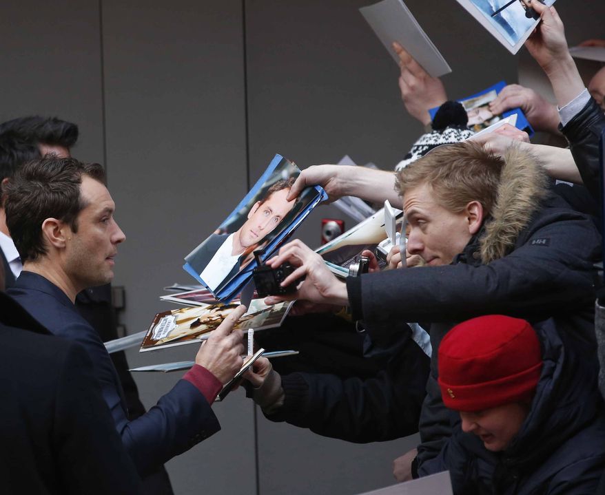 Actor Jude Law signs autographs as he arrives for the photo call of the film Side Effects at the 63rd edition of the Berlinale, International Film Festival in Berlin, Tuesday, Feb. 12, 2013. (AP Photo/Michael Sohn)