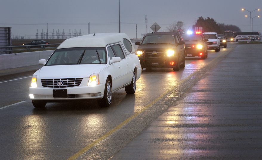 A hearse containing former Navy SEAL Chris Kyle's casket leads a motorcade leaving the Multi-Purpose Stadium in Midlothian, Texas, on Feb. 12, 2013 for the 200-mile journey to Austin, where Kyle will be buried at the Texas State Cemetery. Kyle and his friend Chad Littlefield were shot and killed Feb 2. at a North Texas gun range. (Associated Press/Star-Telegram)