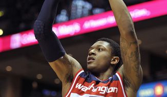 Washington Wizards&#39; Bradley Beal (3) shoots a three point basket against the Milwaukee Bucks during the first half of an NBA basketball game Monday, Feb. 11, 2013, in Milwaukee. (AP Photo/Jim Prisching)