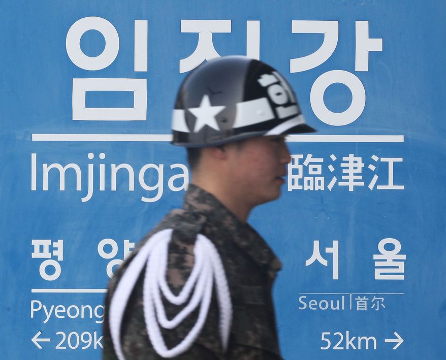 A South Korean army soldier walks by a sign showing the distance to North Korean capital Pyongyang and that for South's capital Seoul from Imjingang Station near the border village of Panmunjom in Paju, South Korea, Thursday, Feb. 14, 2013. (AP Photo/Ahn Young-joon)