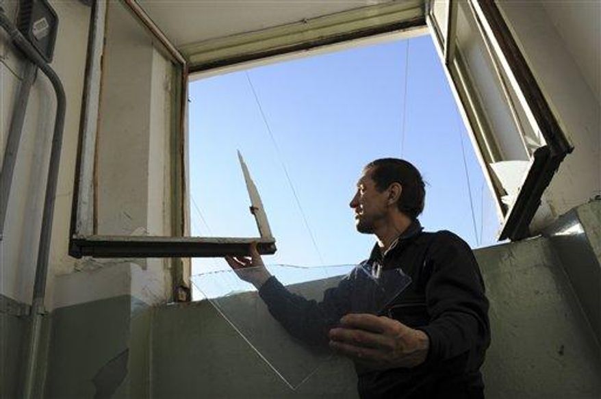 A local resident repairs a window broken by a shock wave from a meteor explosion in Chelyabinsk, about 930 miles east of Moscow, Friday, Feb. 15, 2013. A meteor that scientists estimate weighed 10 tons streaked at supersonic speed over Russia's Ural Mountains on Friday, setting off blasts that injured some 500 people and frightened countless more. (Associated Press)