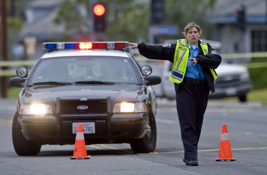 A police officer directs traffic as the investigation of a shooting spree in Orange County, Calif., continues on Tuesday, Feb. 19, 2013. (AP Photo/The Orange County Register, Mark Rightmire)