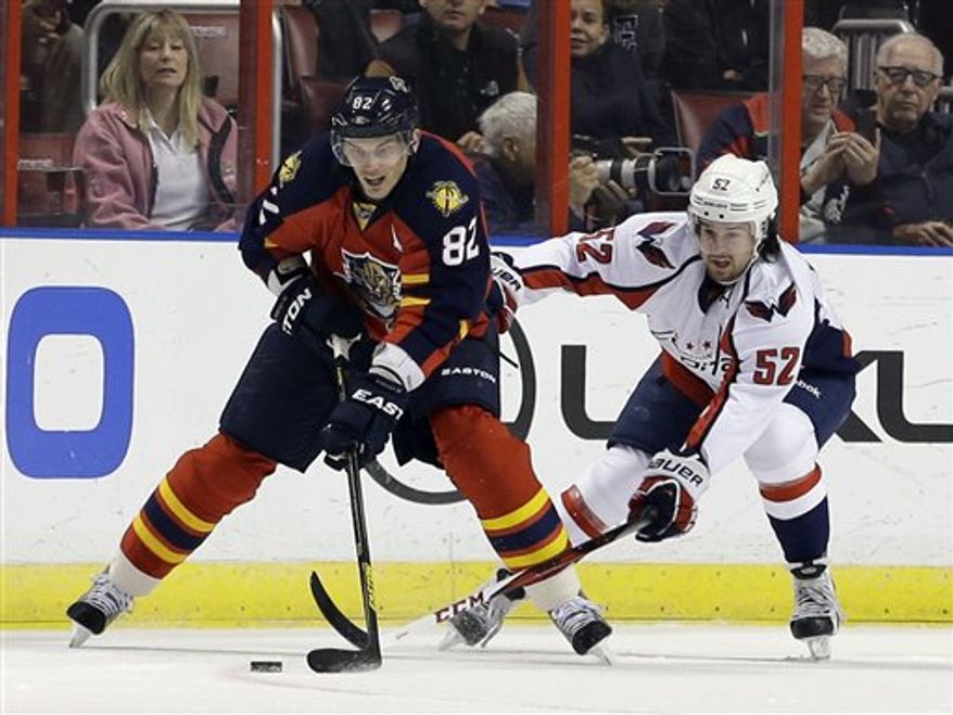 Florida Panthers center Tomas Kopecky (82) of Slovakia, and Washington Capitals defenseman Mike Green (52) of Canada, battle for the puck during the first period of an NHL hockey game, Tuesday, Feb. 12, 2013 in Sunrise, Fla. (AP Photo/Wilfredo Lee)