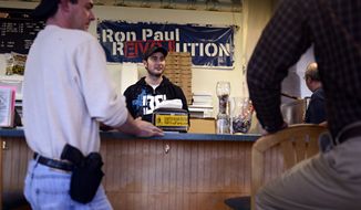 Jay Laze (center) talks with customers including Andy Elliott (left), who brought his 9 mm handgun to All Around Pizza and Deli in Virginia Beach on Monday, Feb. 8, 2013. Any customer at the pizzeria who carries a gun or brings a concealed-handgun permit is offered at 15 percent discount. (AP Photo/The Virginian-Pilot, Amanda Lucier)