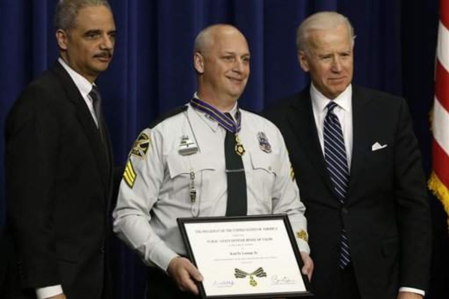 Vice President Joe Biden and Attorney General Eric Holder present the Medal of Valor to St. Petersburg, Fla., Police Sgt. Karl Lounge, Jr., Wednesday, Feb. 20, in the Eisenhower Executive Office Building on the White House complex in Washington. The medal is the highest national award for valor by a public safety officer. (Associated Press)