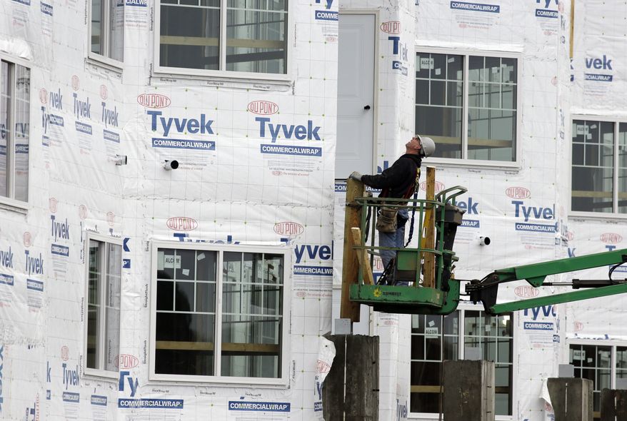 A construction worker checks out at a new home being built in Chicago on Friday, Jan. 11, 2013. (AP Photo/Nam Y. Huh)