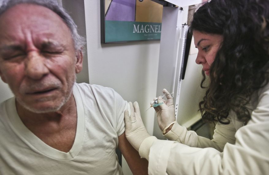 Carlos Maisonet, 73, receives a flu shot from Dr. Eva Berrios-Colon, a professor at Touro College of Pharmacy, during a visit to the faculty practice center at Brooklyn Hospital in New York on Tuesday, Jan. 15, 2013. (AP Photo/Bebeto Matthews)