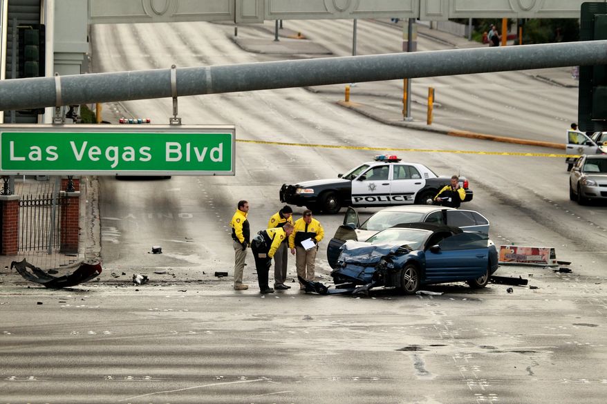 Law enforcement personal in Las Vegas investigate the scene of a multi-vehicle accident on Las Vegas Blvd. and Flamingo Road on Feb. 21, 2013. Authorities say a Range Rover opened fire on a Maserati at a stoplight, sending it crashing into a taxi that went up in flames, leaving three people dead and at least six injured. (Associated Press/Las Vegas Review-Journal)