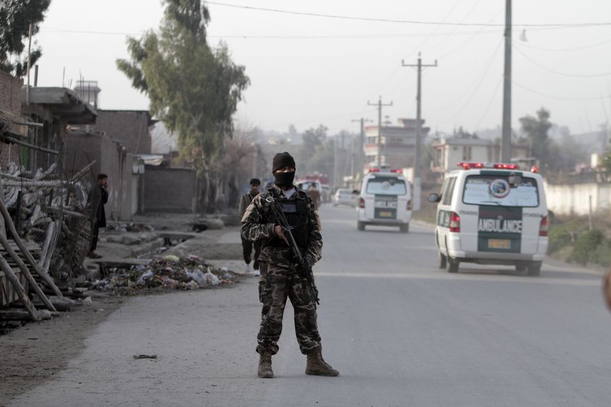A security official stands guard at the scene of a suicide car bomb attack at the National Directorate of Security in Jalalabad, Afghanistan, on Sunday, Feb. 24, 2013. A series of early morning attacks hit in the country's east on Sunday, with three separate suicide bombings in outlying provinces and a shootout between security forces and a would-be attacker in the capital of Kabul. (AP Photo/Rahmat Gul)