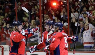 Washington Capitals center Nicklas Backstrom, left, from Sweden, right wing Troy Brouwer (20) and center Mike Ribeiro (9) celebrate Backstrom&#39;s goal in the first period of an NHL hockey game against the Carolina Hurricanes on Tuesday, Feb. 26, 2013, in Washington. (AP Photo/Alex Brandon)