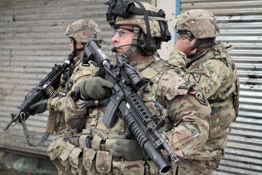 ** FILE ** U.S. soldiers stand guard at the scene of a suicide attack in Kabul, Afghanistan, Wednesday, Feb. 27, 2013. (AP Photo/Musadeq Sadeq)