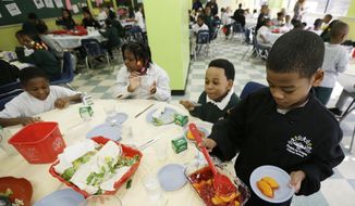 ** FILE ** A student serves up dessert to classmates during lunch at the People for People Charter School on Monday, Feb. 25, 2013, in Philadelphia. (AP Photo/Matt Rourke)

