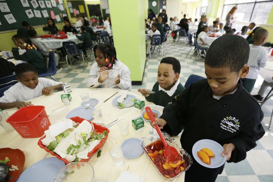 ** FILE ** A student serves up dessert to classmates during lunch at the People for People Charter School on Monday, Feb. 25, 2013, in Philadelphia. (AP Photo/Matt Rourke)