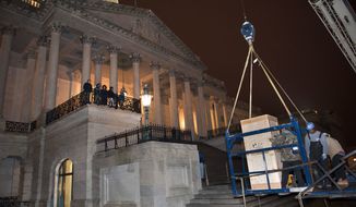 Riggers load a crate containing the bronze statue of Rosa Parks onto a basket suspended from a crane as it is delivered to the U.S. Capitol&#39;s Memorial Door, in Washington, Friday, Feb. 22, 2013, where it will join the U.S. Capitol Art Collection. Authorized by Public Law 109-116, as modified by Public Law 110-120, the Rosa Parks statue represents the first commission of a full-sized statue approved and funded by the U.S. Congress since 1873. It will be installed in National Statuary Hall in the United States Capitol on Feb. 27, 2013. (AP Photo/Cliff Owen)
