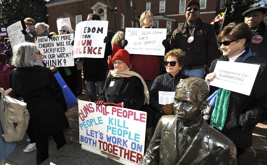 Supporters of the Firearms Safety Act wave their signs protesting against gun violence at the Prevent Gun Violence Rally on Lawyer's Mall in front of the State House in Annapolis on March 1, 2013. The bill would ban assault weapons and require people who buy handguns to get a license and submit fingerprints. It also would limit magazine capacity to 10 rounds and prohibit anyone who has been involuntarily committed due to mental illness from possessing a firearm. (Associated Press/Capital Gazette)