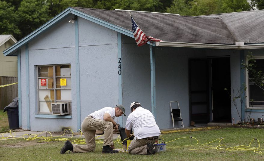 Engineers work in front of a home where sinkhole opened up underneath a bedroom and swallowed a man Friday, March 1, 2013, in Seffner, Fla. (AP Photo/Chris O'Meara)