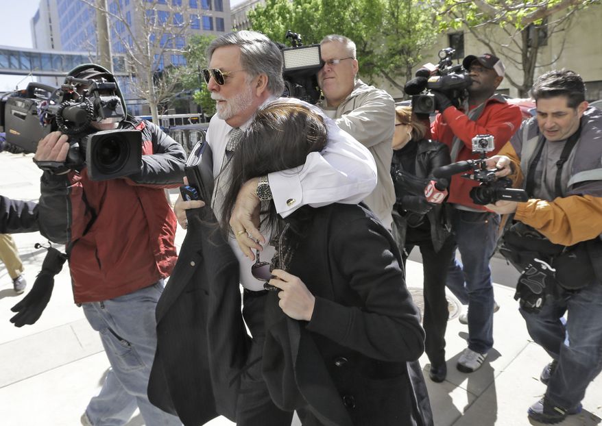 Casey Anthony is protected from the media by her attorney, Cheney Mason, as she arrives at the U.S. Courthouse in Tampa, Fla., for a bankruptcy hearing on Monday, March 4, 2013. Ms. Anthony has not been seen in public since being acquitted in 2011 of murdering her 2-year-old daughter, Caylee. (AP Photo/Chris O'Meara)