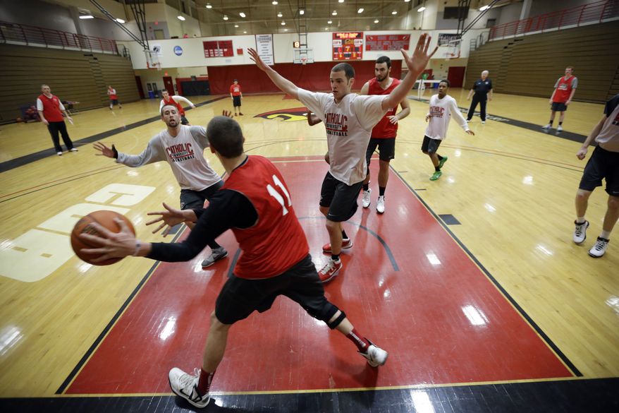 In this photo taken Feb. 12, 2013, Catholic University players workout during an NCAA college basketball practice in Washington. The men's and women's teams at the Division III school are have a combined record of 42-4. (AP Photo/Alex Brandon)