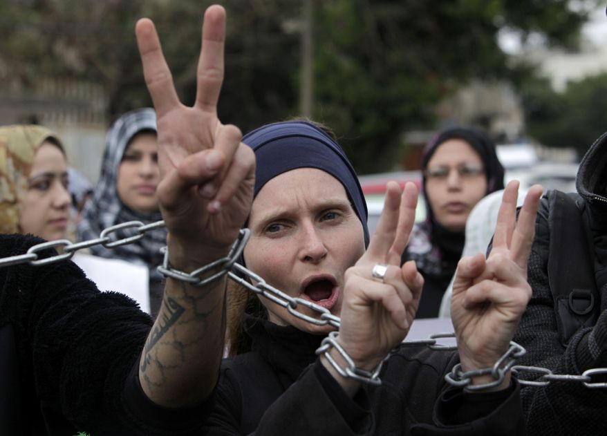 ** FILE ** Palestinians and foreign activists chant slogans as they march with their hands chained together during a protest held in solidarity with Palestinian prisoners held in Israeli jails in Gaza City, Thursday, Feb. 14, 2013. (AP Photo/Adel Hana)