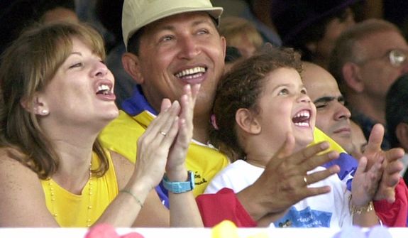FILE - In this July 15, 2001 file photo, Venezuela&#39;s President Hugo Chavez, center, his wife Marisabel with their daughter Rosa Ines watch a parade on Children&#39;s Day in Caracas, Venezuela. Venezuela&#39;s Vice President Nicolas Maduro announced on Tuesday, March 5, 2013 that Chavez has died at age 58 after a nearly two-year bout with cancer. During more than 14 years in office, Chavez routinely challenged the status quo at home and internationally. He polarized Venezuelans with his confrontational and domineering style, yet was also a masterful communicator and strategist who tapped into Venezuelan nationalism to win broad support, particularly among the poor.  (AP Photo/Ivan Gonzalez, File)