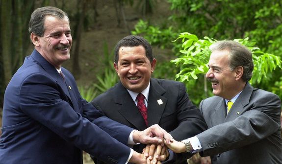 In this April 8, 2001, file photo, Mexico&#39;s then-President Vicente Fox, left, Venezuela&#39;s President Hugo Chavez, center, and Colombia&#39;s President Andres Pastrana shake hands as they pose for a photo in Caracas, Venezuela. (AP Photo/Fernando Llano, File)