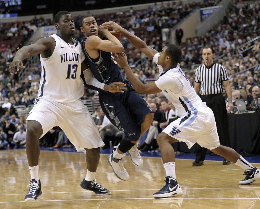 Georgetown&#x27;s Markel Starks, middle, drives between Villanova&#x27;s Tony Chennault, right, and Mouphtaou Yarou, left, during the first half of an NCAA college basketball game, Wednesday, March 6, 2013, in Philadelphia. (AP Photo/Michael Perez)