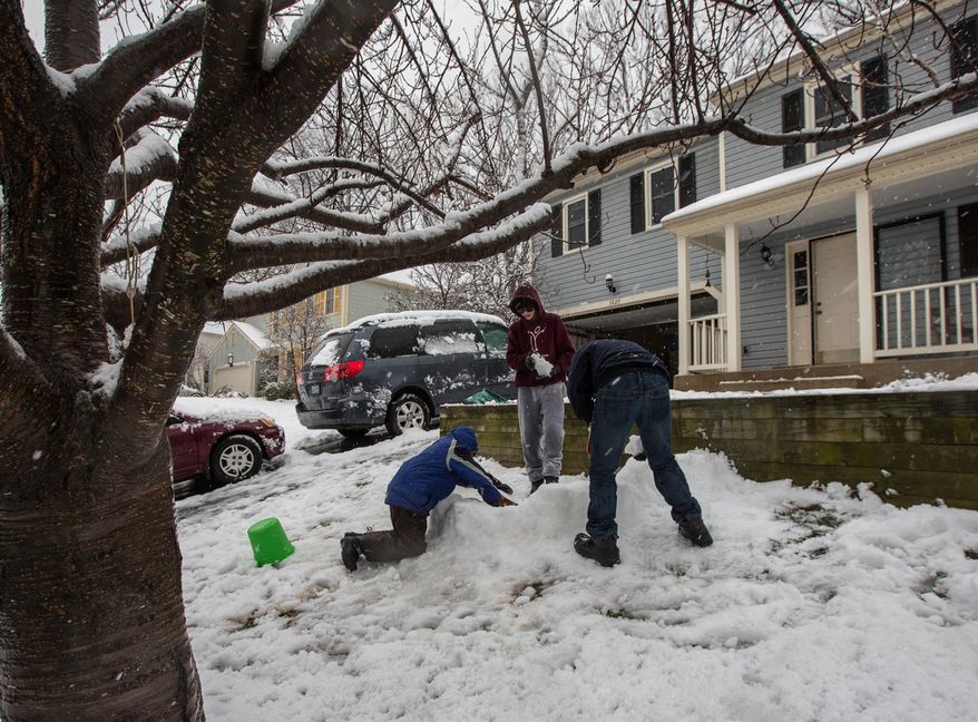 Mason Moy (center), 14, Sam Gustason (right), 13, and Calvin Crist, 13, build a snow fort in a front yard during a snow day in Fairfax, Va., on March 6, 2013. (Andrew S. Geraci/The Washington Times)