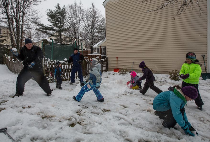The Sweeney and Powers families engage in a snowball fight in Fairfax, Va., on March 6, 2013. (Andrew S. Geraci/The Washington Times)