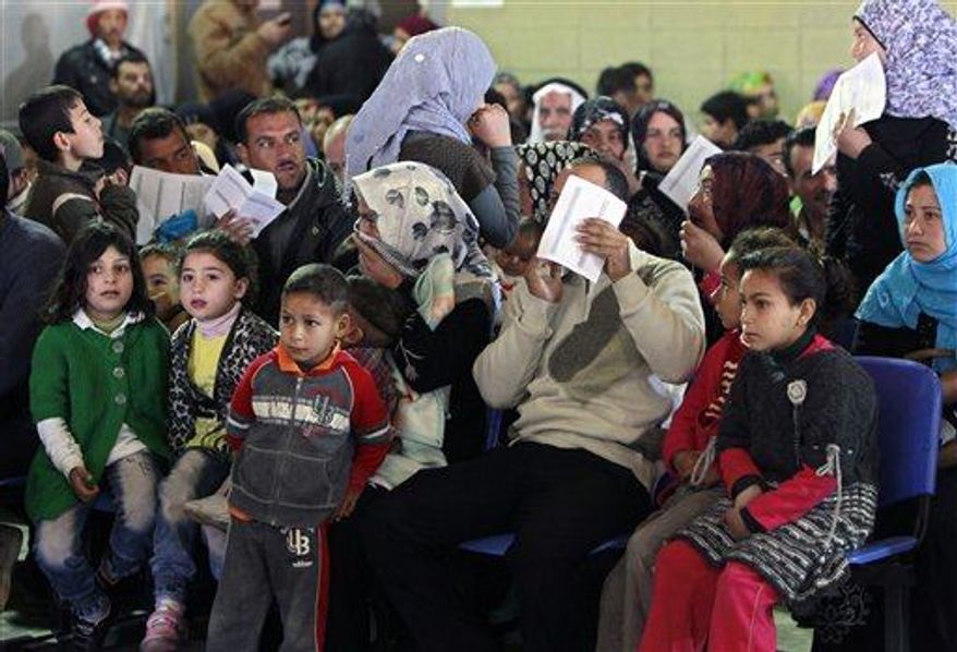 Syrian families wait their turn to register at the UNHCR center in the northern city of Tripoli, Lebanon, Wednesday, March 6, 2013. The number of Syrians who have fled their war-ravaged country and are seeking assistance has now topped the one million mark, the United Nations’ refugee agency said Wednesday warning that Syria is heading towards a "full-scale disaster." (AP Photo/Bilal Hussein)