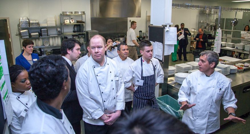 Sina Molavi, executive chef of Occasions Caterers and Embassy Chef Challenge judge (right), walks the chefs through the kitchen before a tough first-round challenge last month. (Jason Morenz)