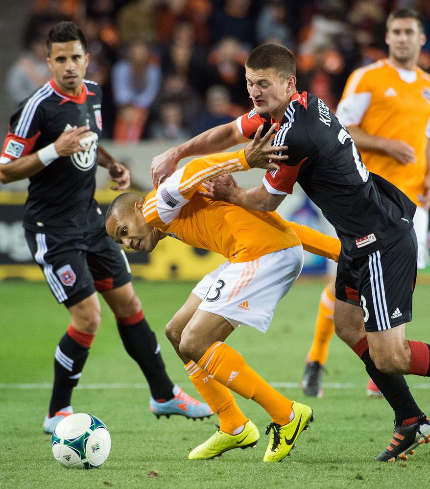 Houston Dynamo midfielder Ricardo Clark (13) tangles with D.C. United midfielder Perry Kitchen (23) during the first half of an MLS soccer match Saturday, March 2, 2013, in Houston. (AP Photo/Houston Chronicle, Smiley N. Pool)
