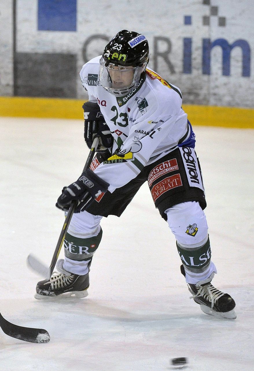 ** FILE ** In this Jan. 22, 2013, file photo Olten's Ronny Keller plays the puck during the Swiss national hockey match between HC La Chaux-de-Fonds and HC Oltenin La Chaux-de-Fonds, Switzerland. Doctors treating Swiss ice hockey player Keller say Thursday, March 7, 2013, he has been left paralyzed by his injuries sustained during a playoff game on Tuesday. (AP Photo/Keystone, Sandro Campardo, File)