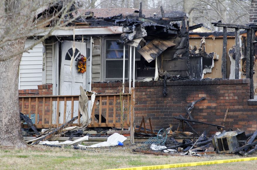 The charred remains of a home in Gray, Ky., are pictured on Sunday, March 10, 2013, after a fire erupted Saturday and killed two adults and five children inside. (AP Photo/Lisa Norman-Hudson)