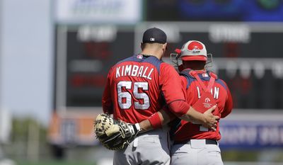 Washington Nationals relief pitcher Cole Kimball (65) and catcher Sandy Leon (41) talk during the eighth inning of an exhibition spring training baseball game against the Detroit Tigers, Sunday, March 10, 2013 in Lakeland, Fla. (AP Photo/Carlos Osorio)